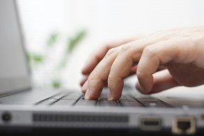 macro of male hands typing on a laptop