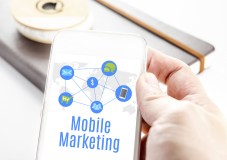 Close up hand holding smart phone with Mobile marketing word and